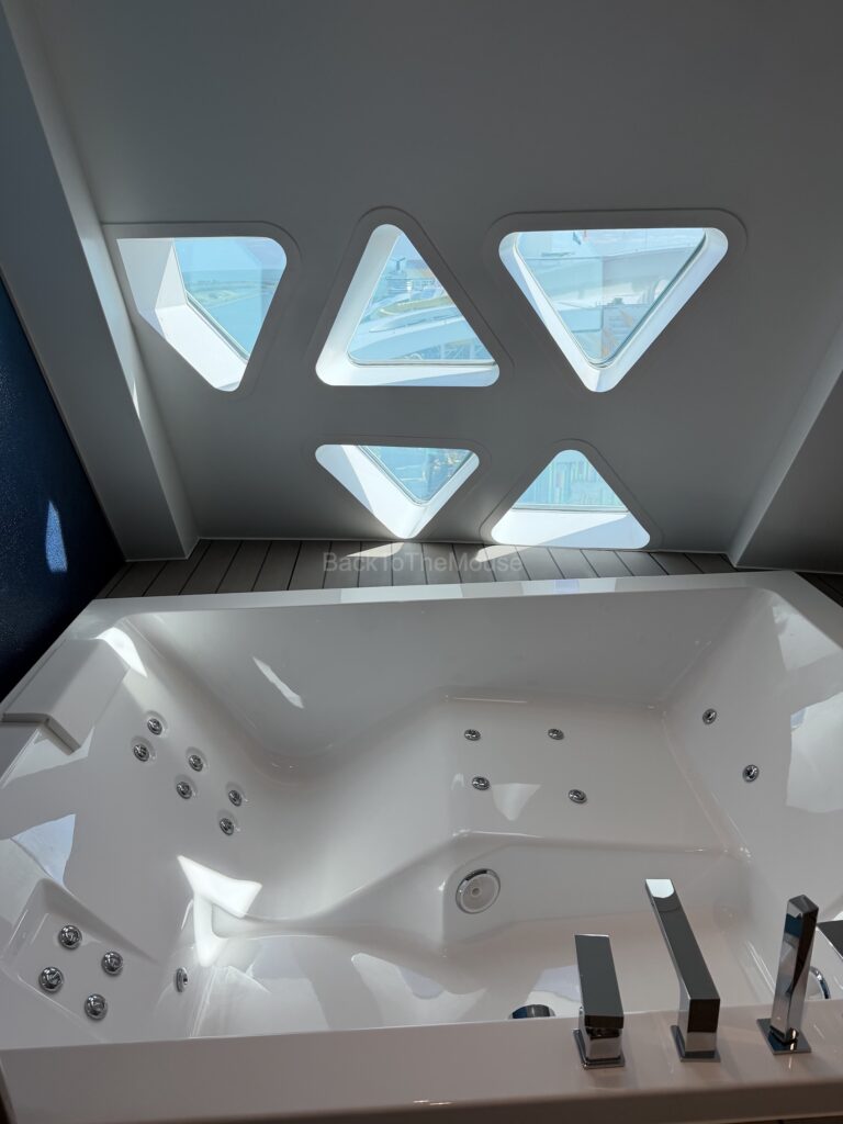 View of a luxurious jacuzzi with triangular windows offering a scenic ocean view.