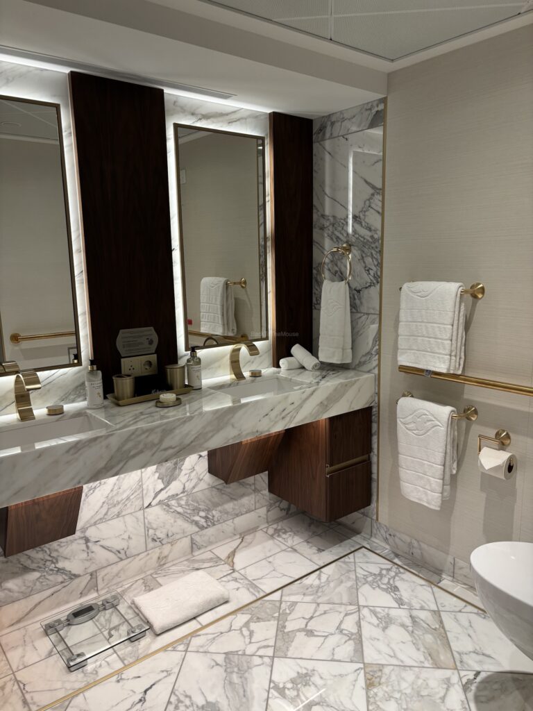 Luxurious bathroom in the Concierge Tower Suite on the Disney Destiny, featuring marble countertops, modern lighting, and elegant fixtures.