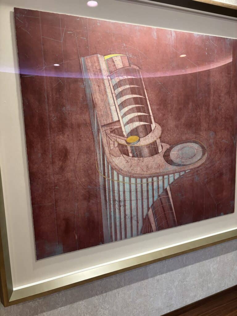 A framed artistic illustration of a cruise ship tower, showcasing its design and architectural features, displayed on a wall.